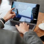 Cropped image of business man sitting by table in cafe